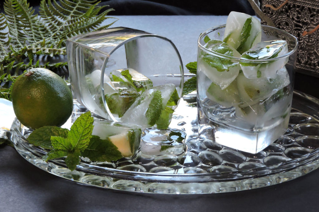 mint and lime ice cubes on a glass tray