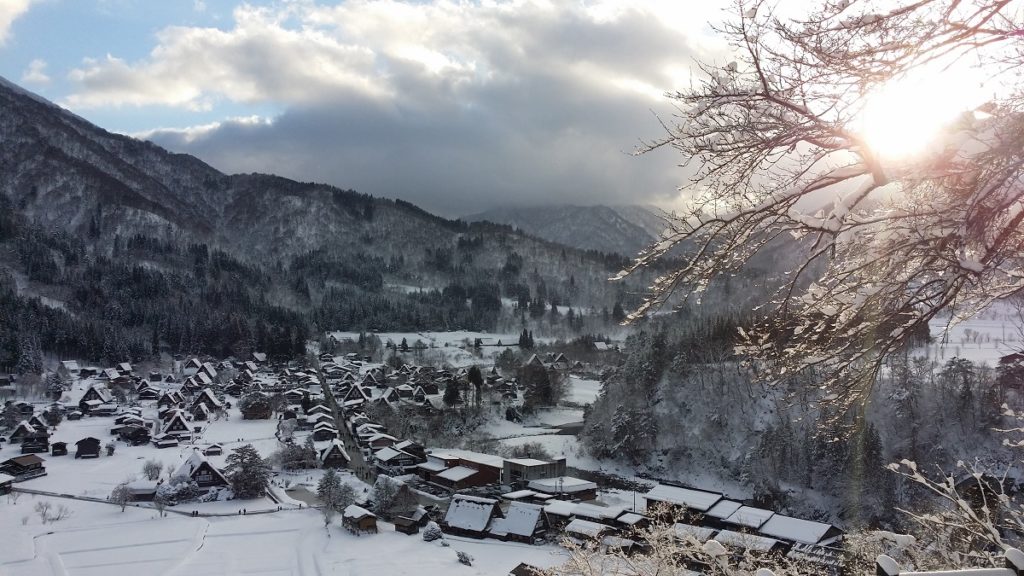 sunlight over the snow covered village of shirakawago