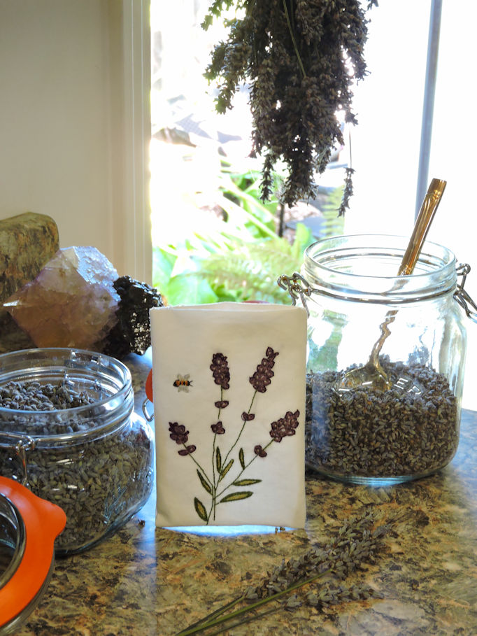 filling the embroidered sachet with dried lavender