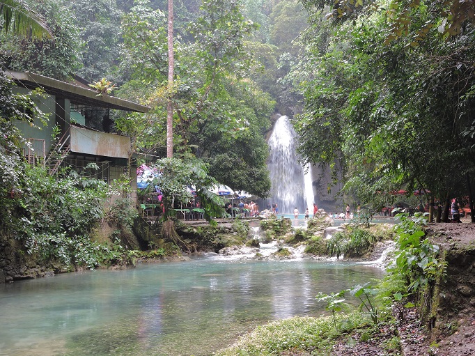 view approaching Kawasan falls with people and buildings