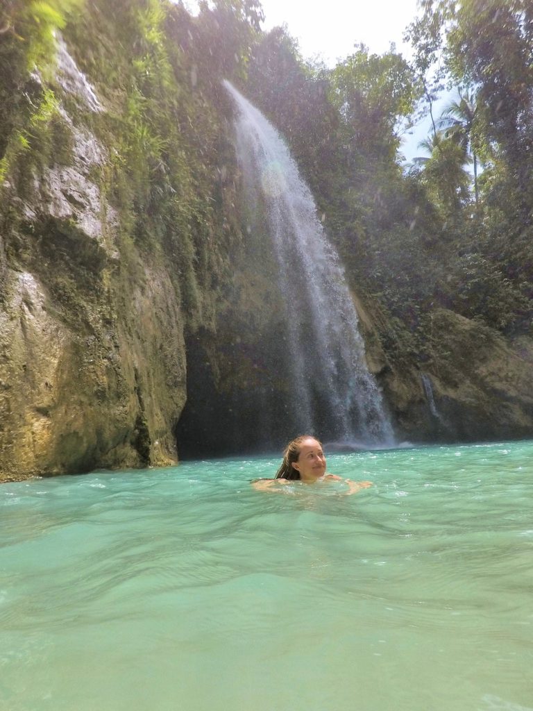 swiming in turquoise blue water jungle behind Inambakan waterfall