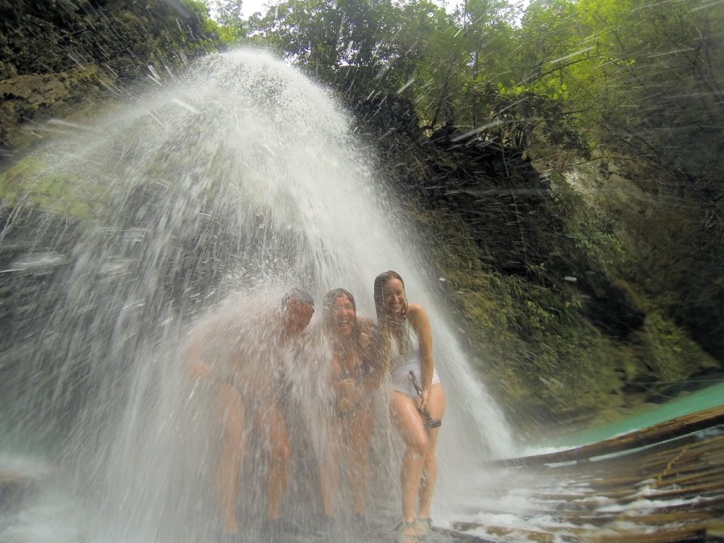 standing under Kawasan falls on a raft