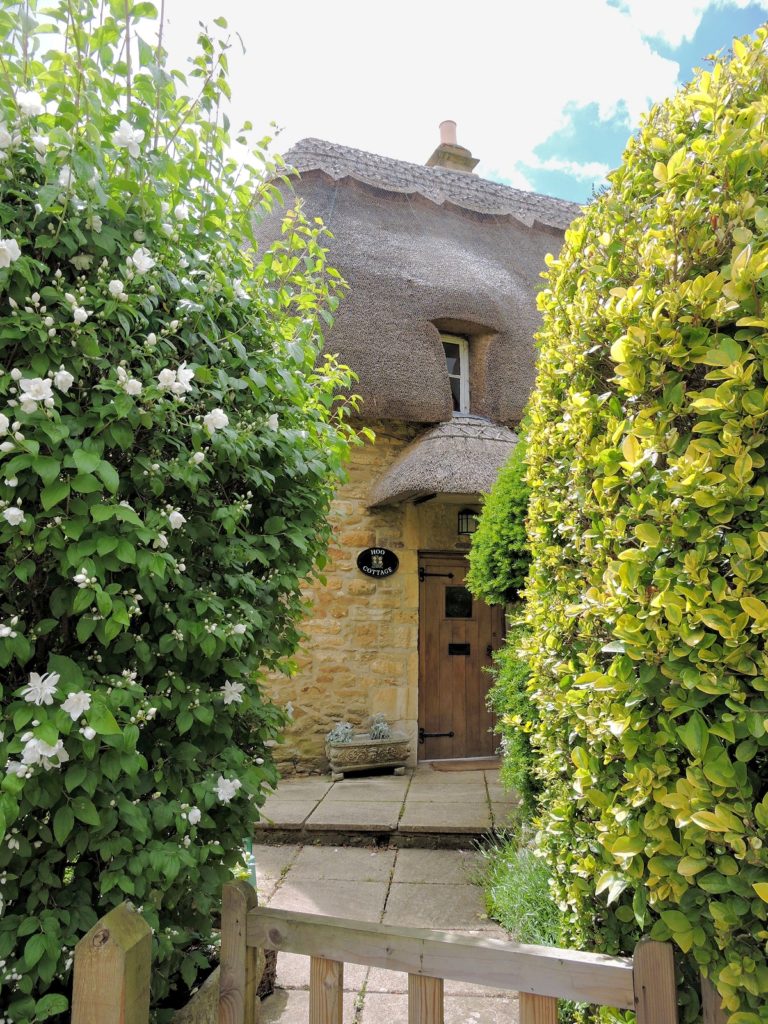 cotswold stone cottage with thatched roof