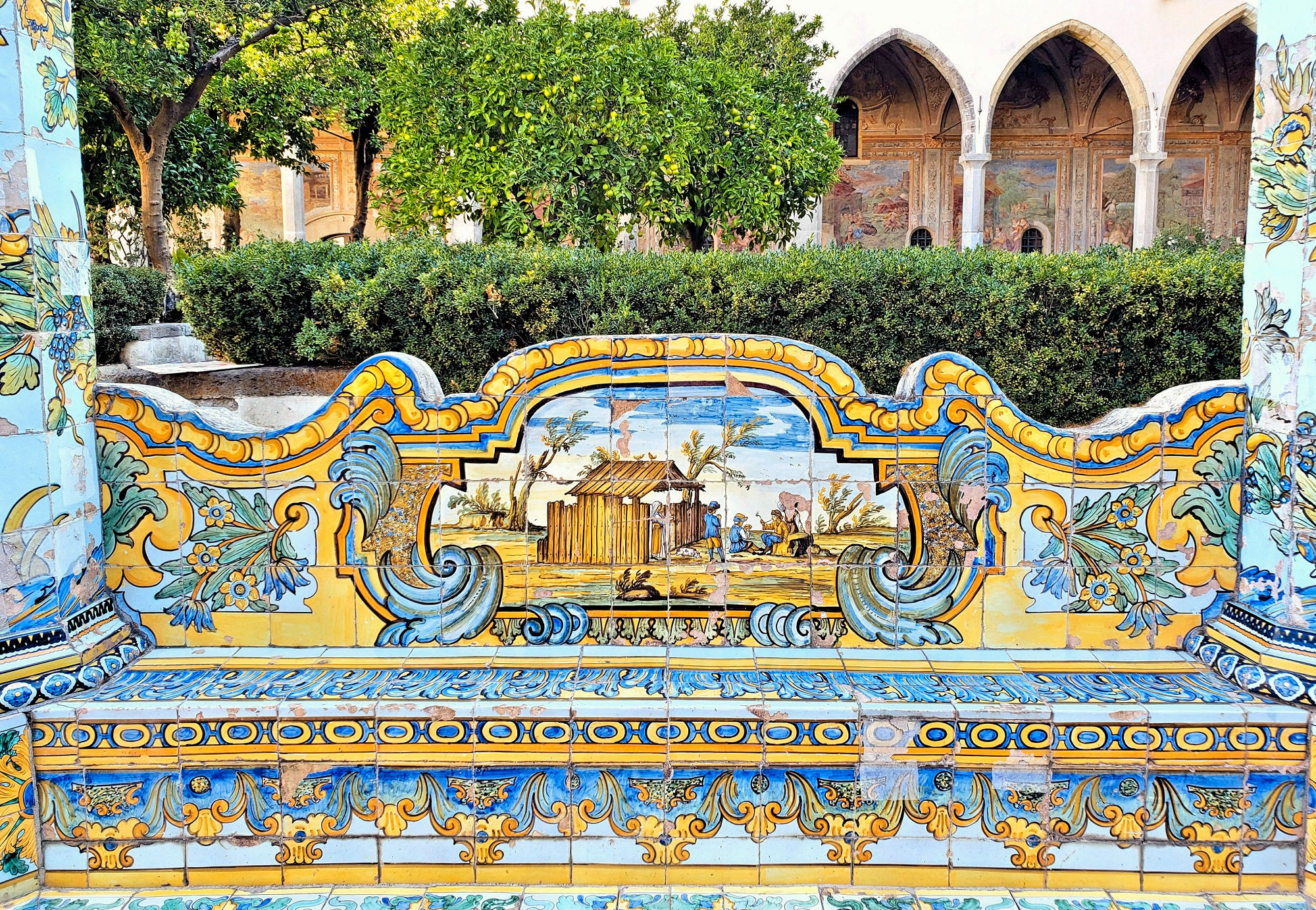 vibrant majolica tiles in santa Chiara cloister citrus trees and fresces in the background