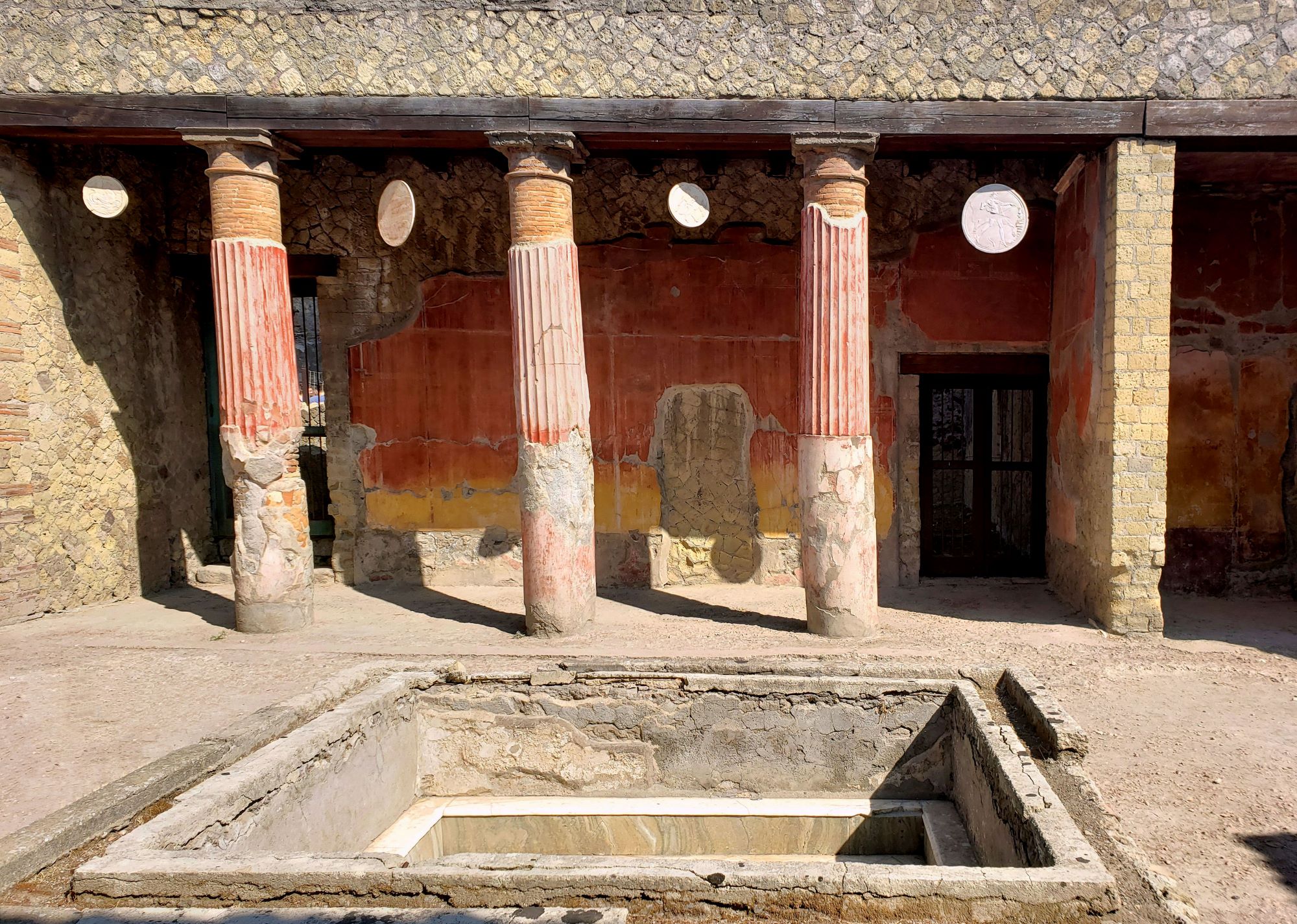 painted columns and hanging cast replicas of oscilla masks