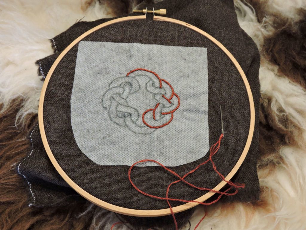 red thread embroidery design in wood hoop using stick and stitch transfer technique