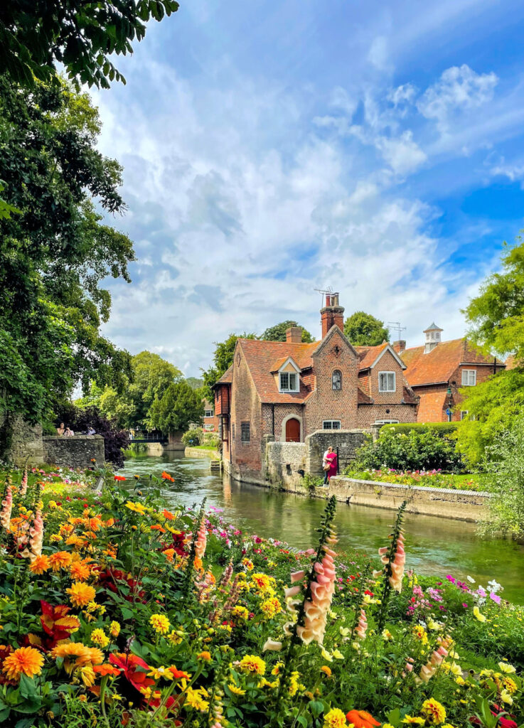 cottage house next to river with flowers