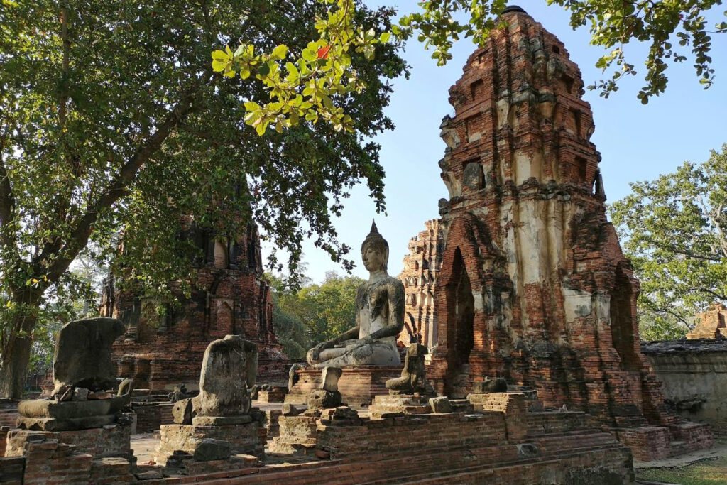 seated stone Buddha and brick temple