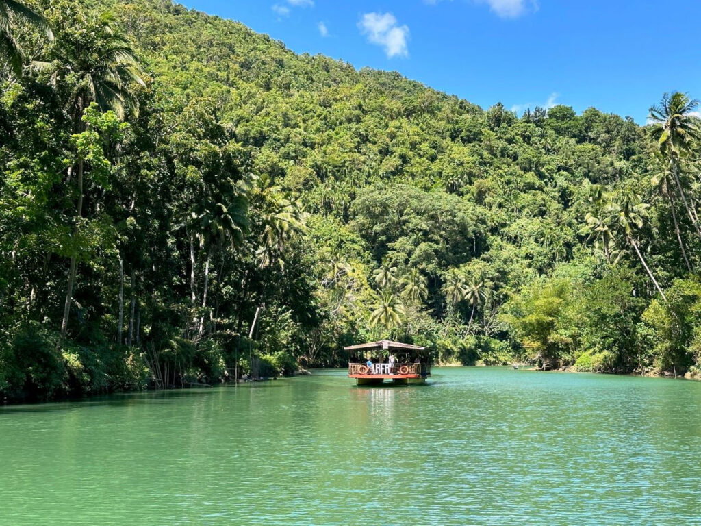 river barge floating down jungle river