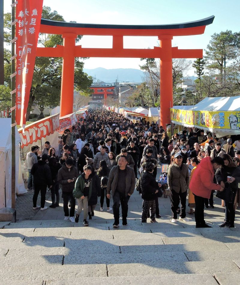 crowds of people approaching fushimi inari shrine