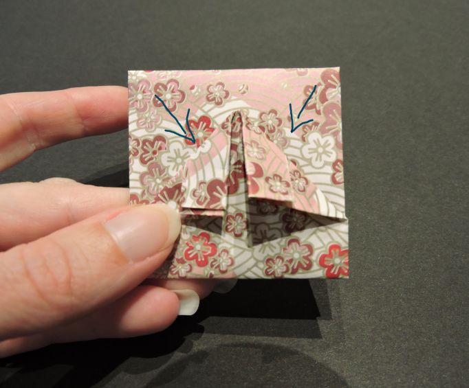 arrows showing how to fold origami paper