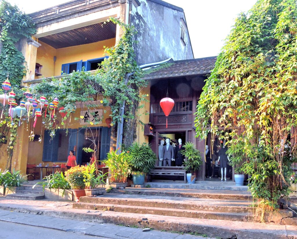 shops and lanterns in ancient old town with foliage