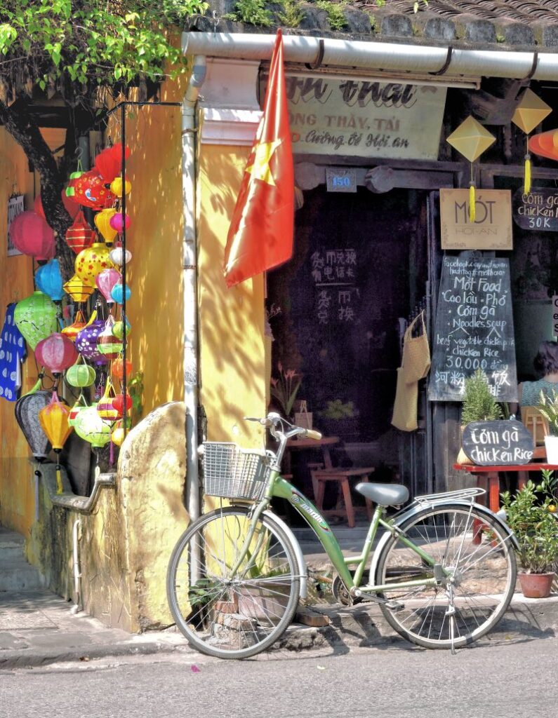 bicycle in front of little cafe with lanterns and Vietnam flag