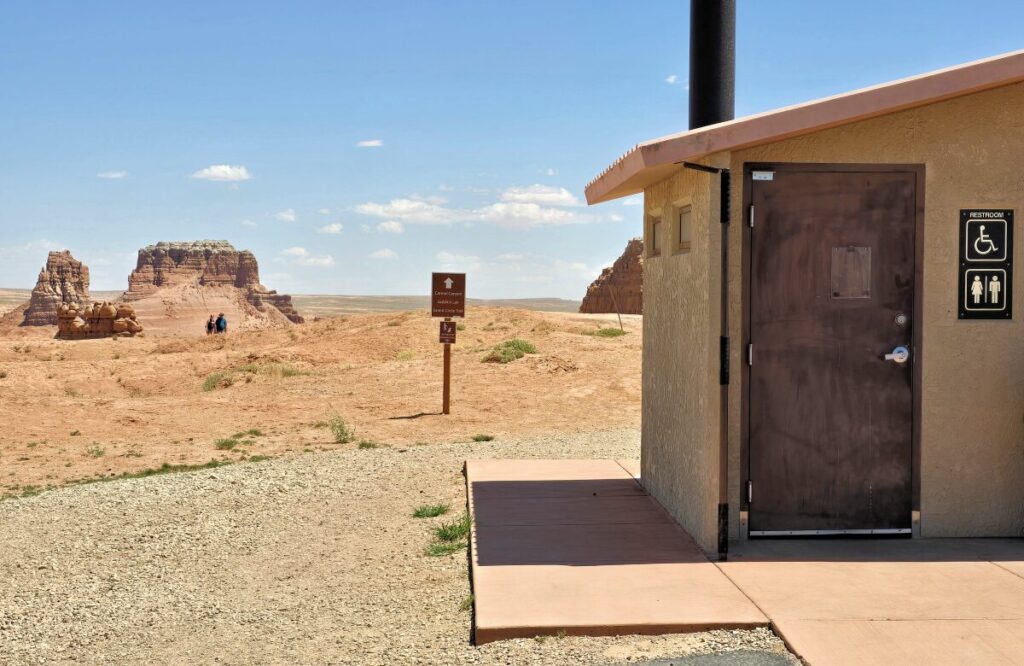 restroom in the parking lot with trailhead behind it