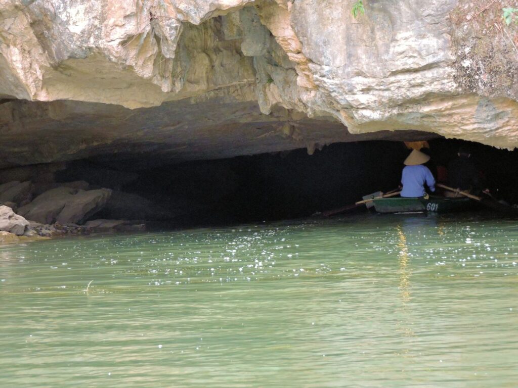 row boat heading into river cave