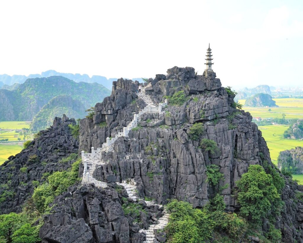 steps leading up to pagoda on top of cliff